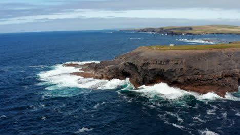 Erstaunliche-Küstenlandschaft.-Blaues-Ozeanwasser,-Das-Auf-Felsklippen-An-Der-Meeresküste-Abstürzt.-Kilkee-Cliff-Walk,-Irland