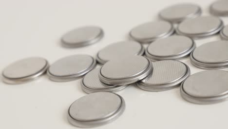 panning over used button batteries close-up 4k video