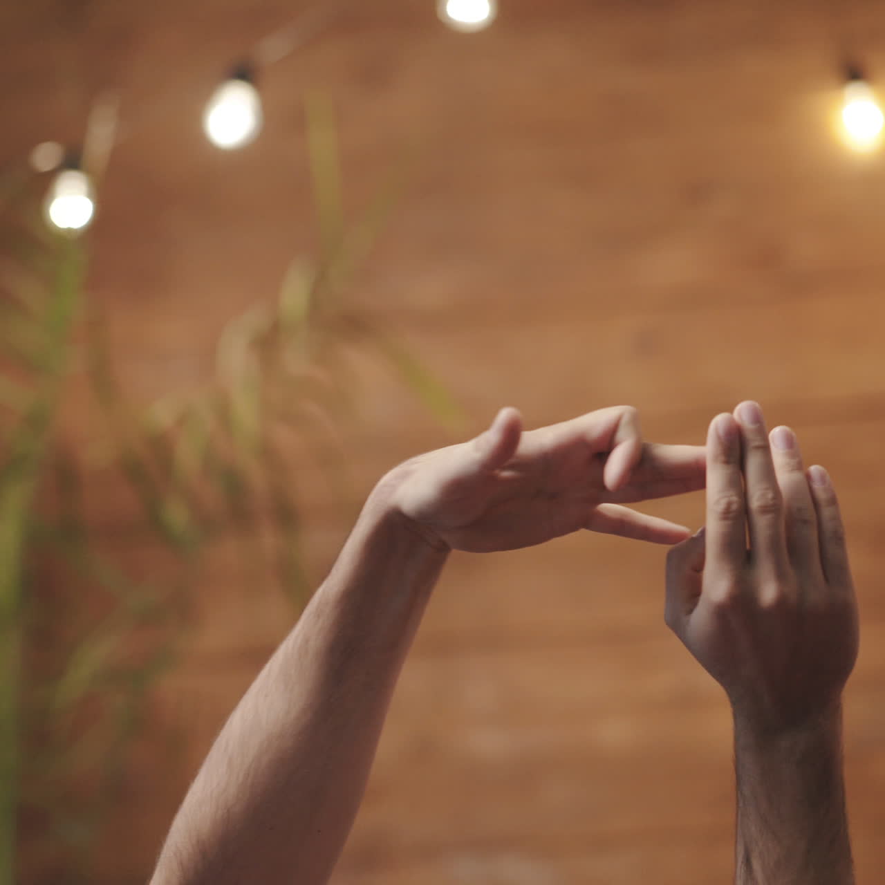 Male's and female's hands making dog gestures playing together. Couple in love shows gestures by their arms on the wooden wall background.