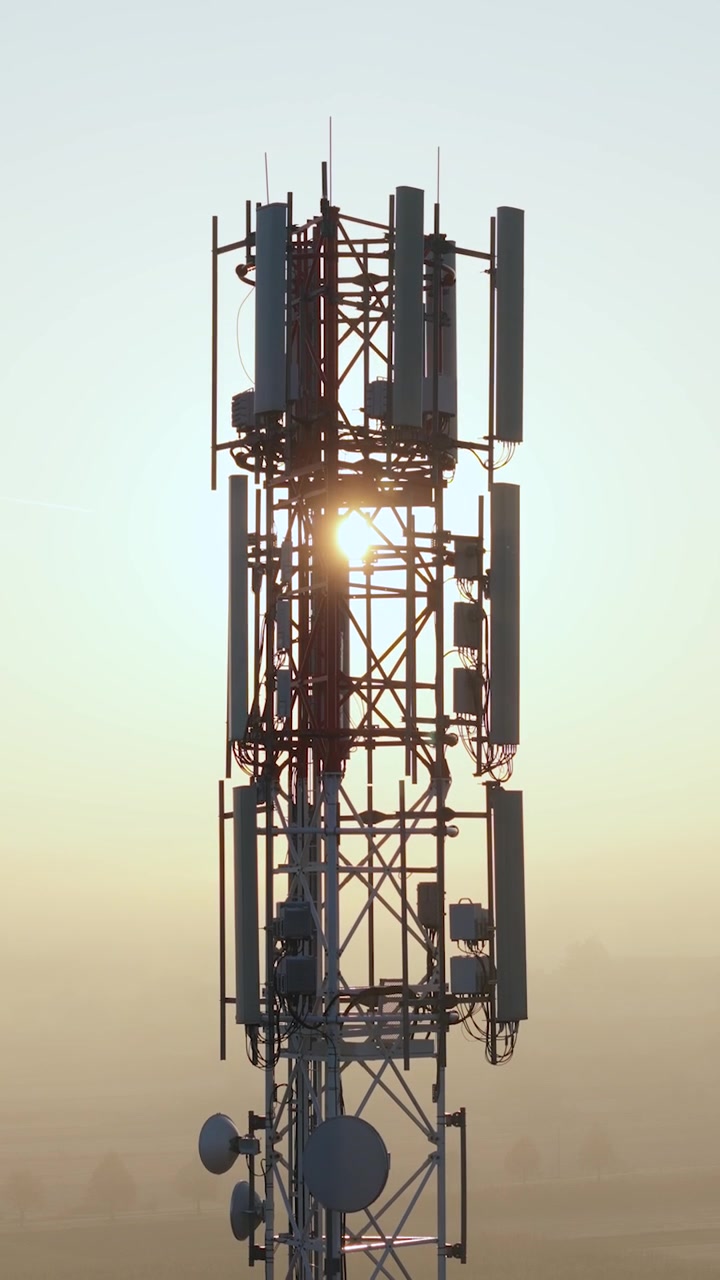 Video verticale di una stazione radio base 5G con tecnologia futuristica e antenne che irradiano onde elettromagnetiche.