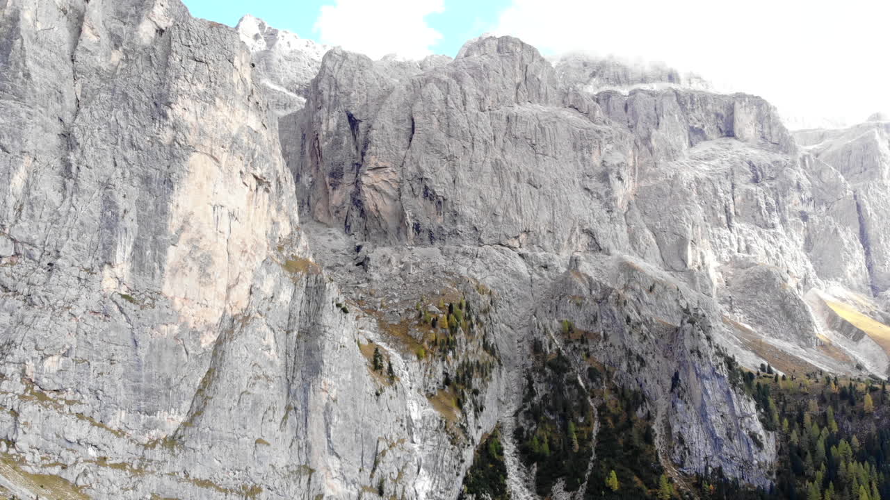 drone volando lejos de la gigantesca cara de la montaña en los alpes dolomitas italianos