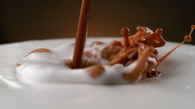 hacer latte o cappuccino - espresso recién elaborado vertiendo a la leche espumada en macro y cámara lenta