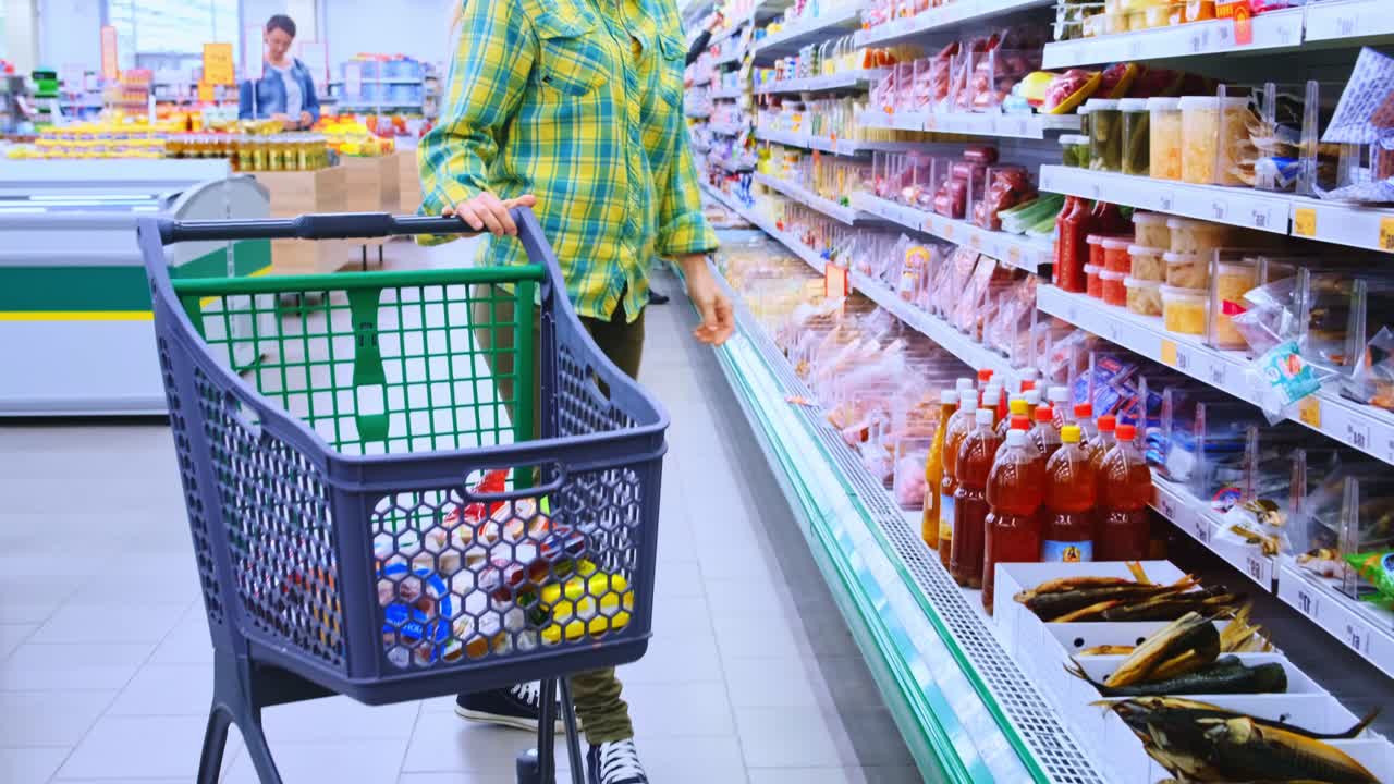 A Shopper in a Grocery Store: Navigating Aisles Filled with Food Products While Pushing a Shopping Cart in a Colorful Supermarket Environment