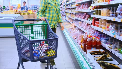 a shopper in a grocery store: navigating aisles filled with food products while pushing a shopping cart in a colorful supermarket environment