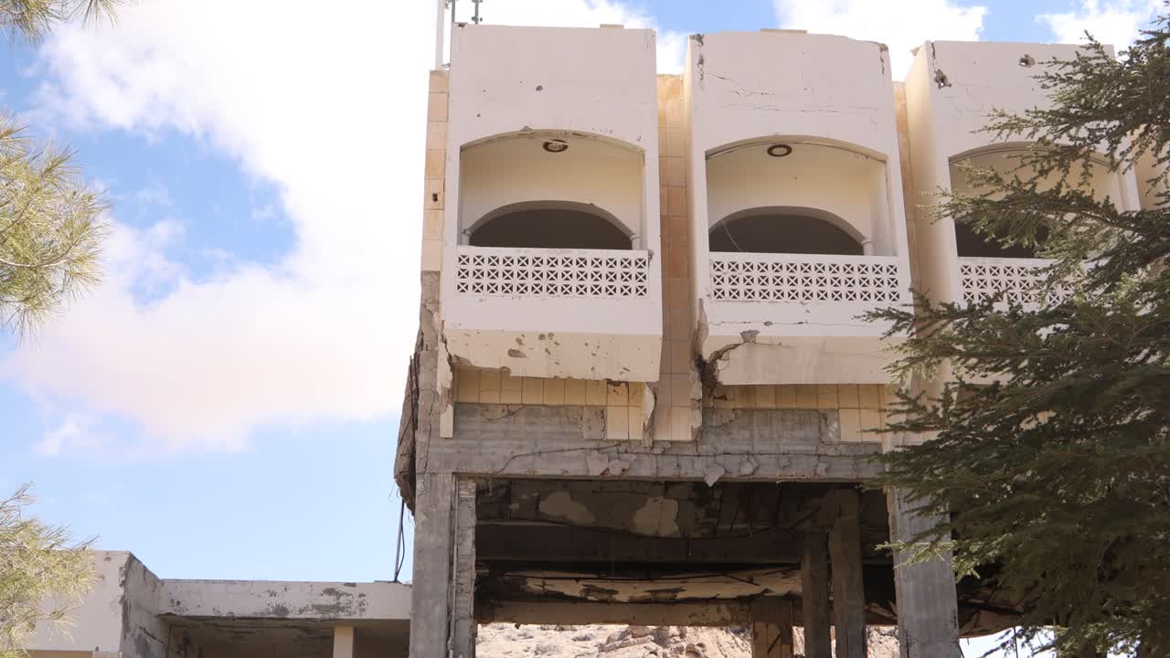 Somber view of the skeletal remains and rubble of a hotel destroyed during the Syrian Civil War in Ma'aloula