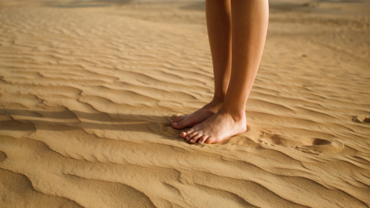 모래 위에 맨발로 있는 사람