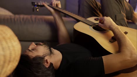 hombre triste tocando la guitarra y acostado en el suelo