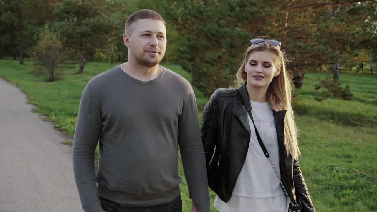 Una pareja caminando en un parque.