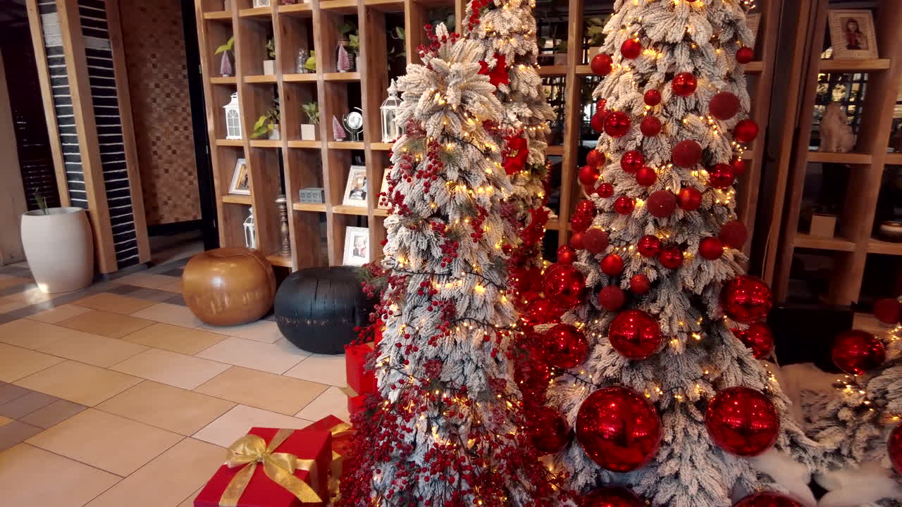 White, decorated Christmas trees with red gift boxes under them
