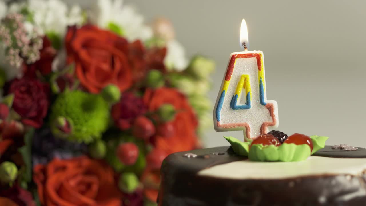arreglo de flores mixtas y pastel de cumpleaños con vela encendida número 4
