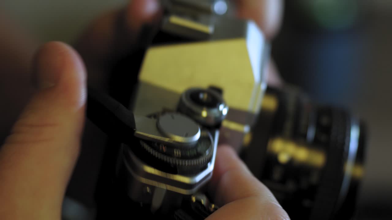 Man uses advance lever on a vintage 35mm camera and takes a photo