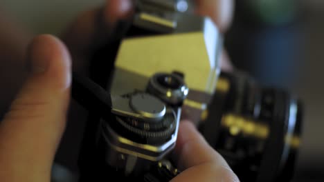 man uses advance lever on a vintage 35mm camera and takes a photo