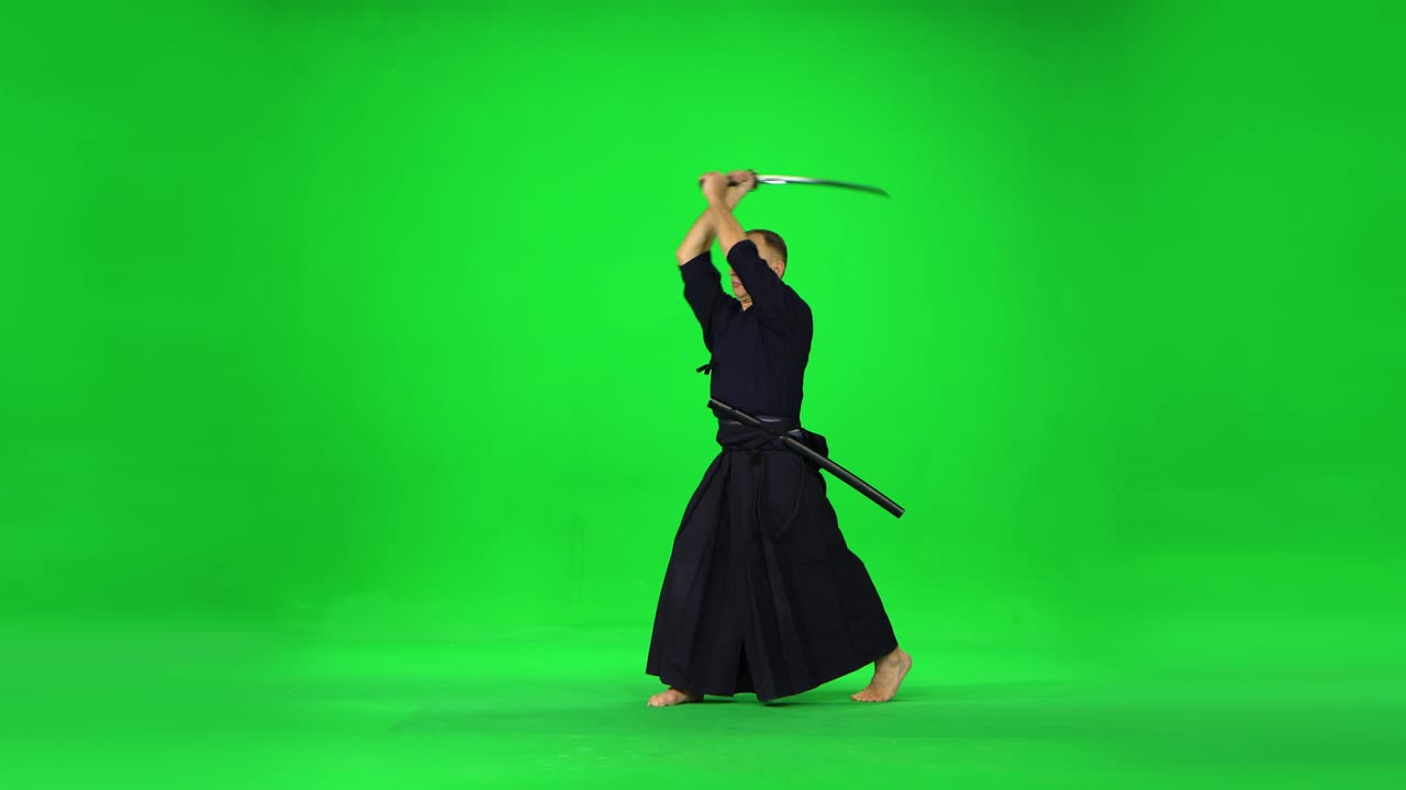 Prajurit Kendo maskulin berlatih seni bela diri dengan bokken bambu di layar hijau