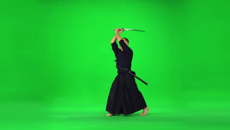 masculine kendo warrior practicing martial art with the bamboo bokken on green screen