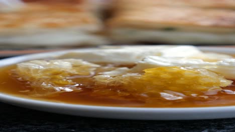 close-up of a dish with honey, honeycomb, and cream