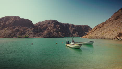 two boats in a tranquil bay, surrounded by mountains