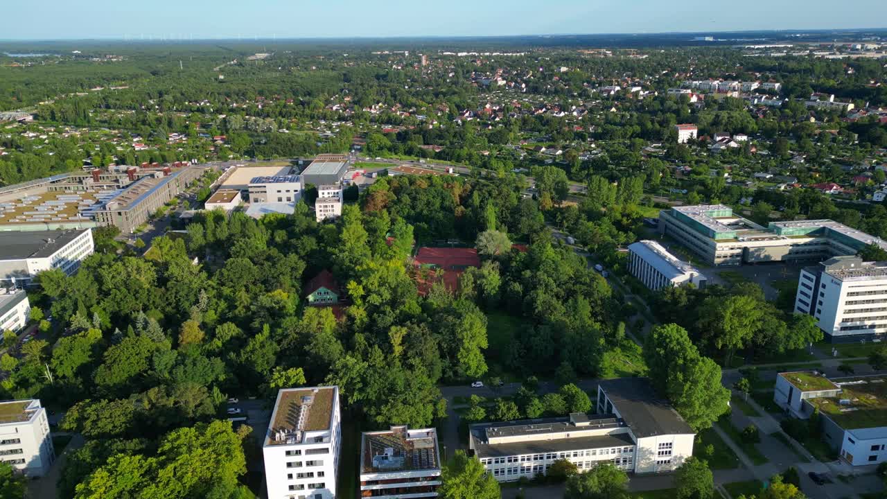 several tennis courts nestled within a dense forest, providing a tranquil escape in the heart of the city Berlin. Fabulous aerial view flight fly push forward drone