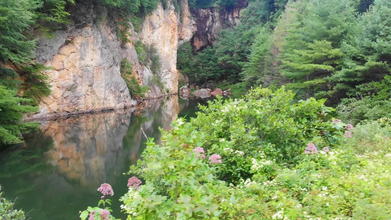 여름날 2일 노스캐롤라이나 리틀 스위스 근처 에메랄드 마을의 나무로 둘러싸인 아름다운 산 연못의 4k 드론 비디오