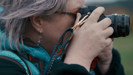 Close-up-shot-of-a-woman-taking-pictures-of-nature-with-her-camera