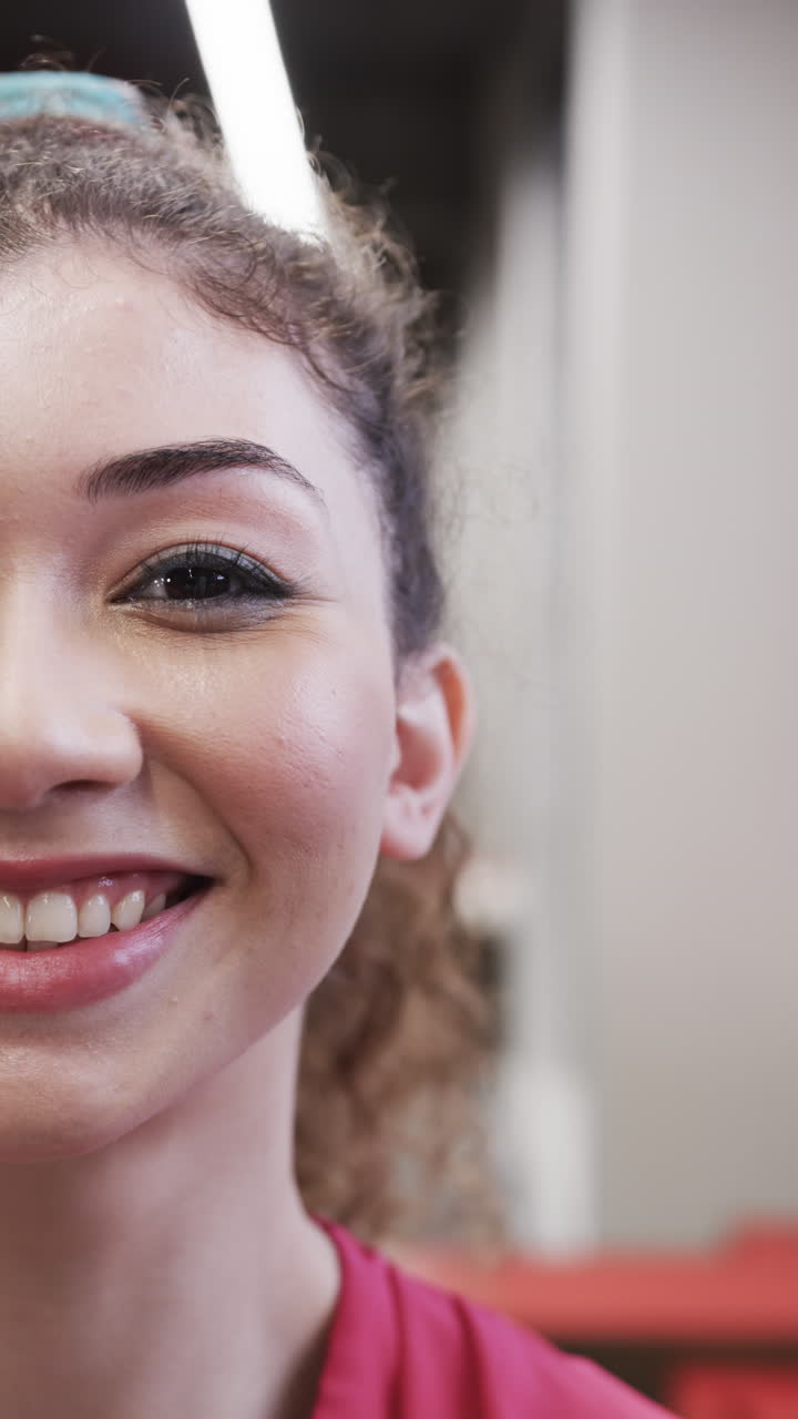 Vertical video of happy biracial female designer in casual office, slow motion