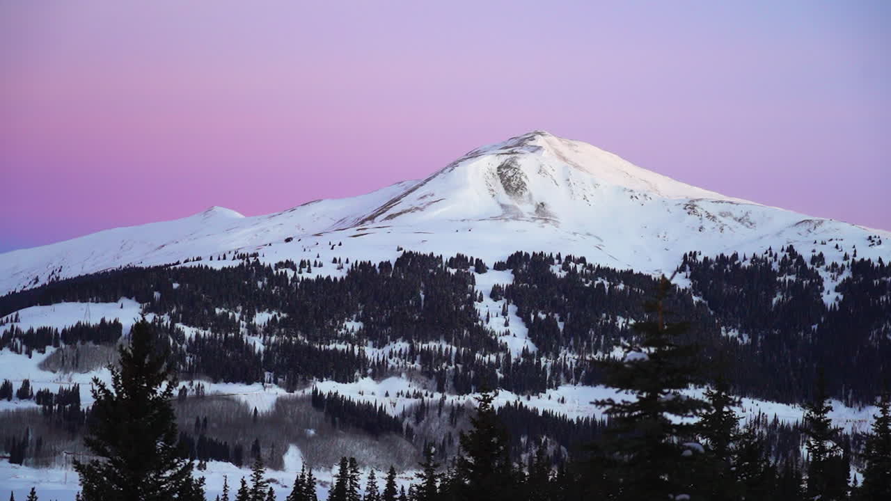 Cinematic purple dramatic stunning Colorado early morning shaded Rocky Mountain peaks backcountry skier snowboarder fresh snow winter Copper Breckenridge Aspen Vail zoom pan