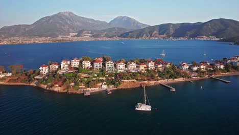 aerial orbit of fethiye island at golden hour, private hotels, apartments and villas