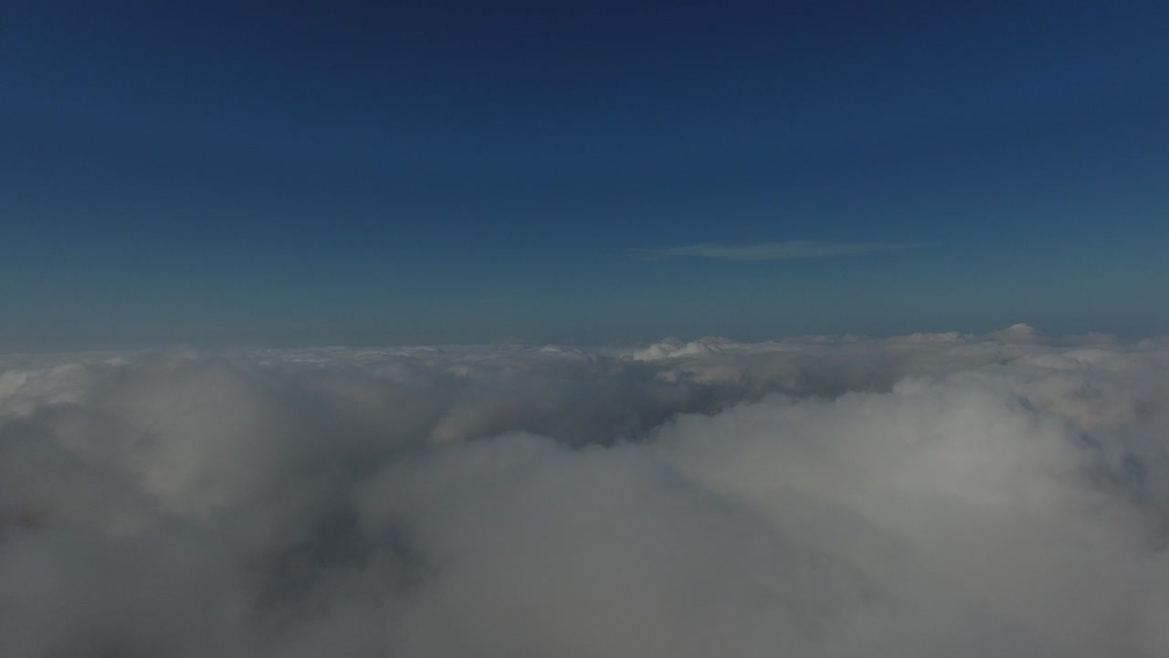 volando sobre las altas montañas en hermosas nubes. vista aérea.