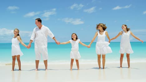 caucasian parents and their young daughters on beach