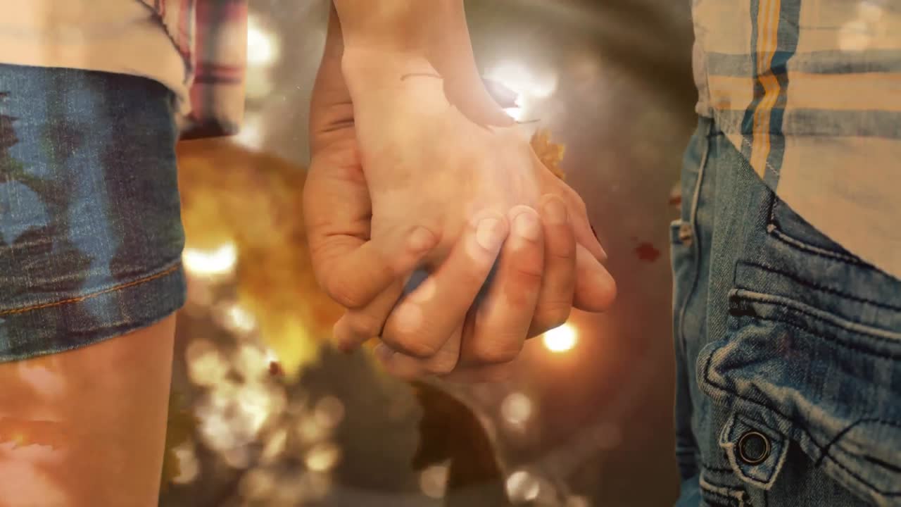 pareja cogida de la mano y hojas de otoño cayendo 4k