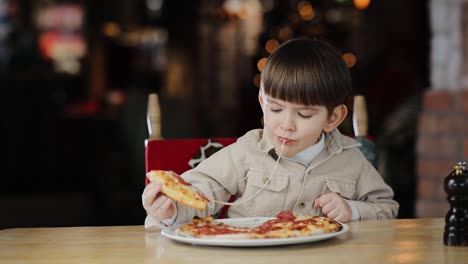 child is playing with cheese from just now cooked fresh pizza