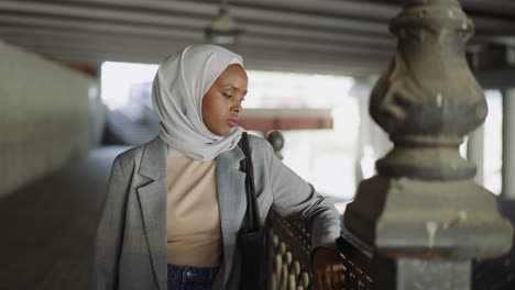 upset african-american woman with headscarf on embankment