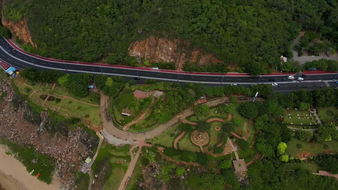 High-altitude aerial drone shot of a shipwreck off Vizag, with the remains of the ship visible amidst the gentle waves of the ocean.