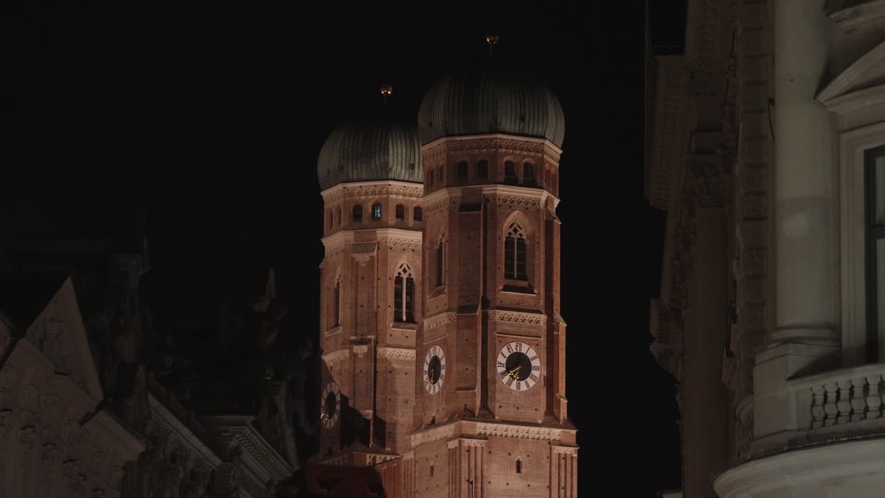 Frauenkirche a Monaco di Baviera di notte, con luci proiettate sulle torri.