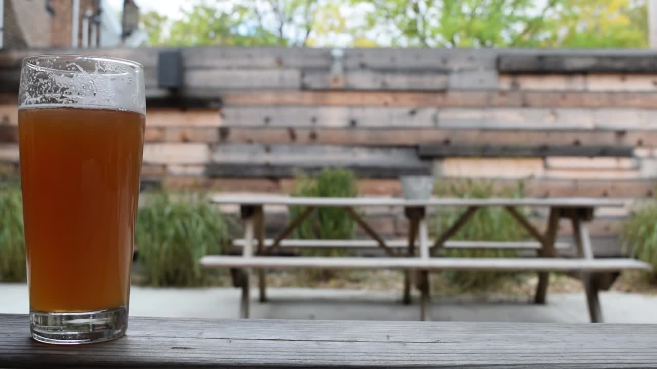 화창한 여름날 뒷마당의 피크닉 테이블에 있는 신선한 맥주 한 잔