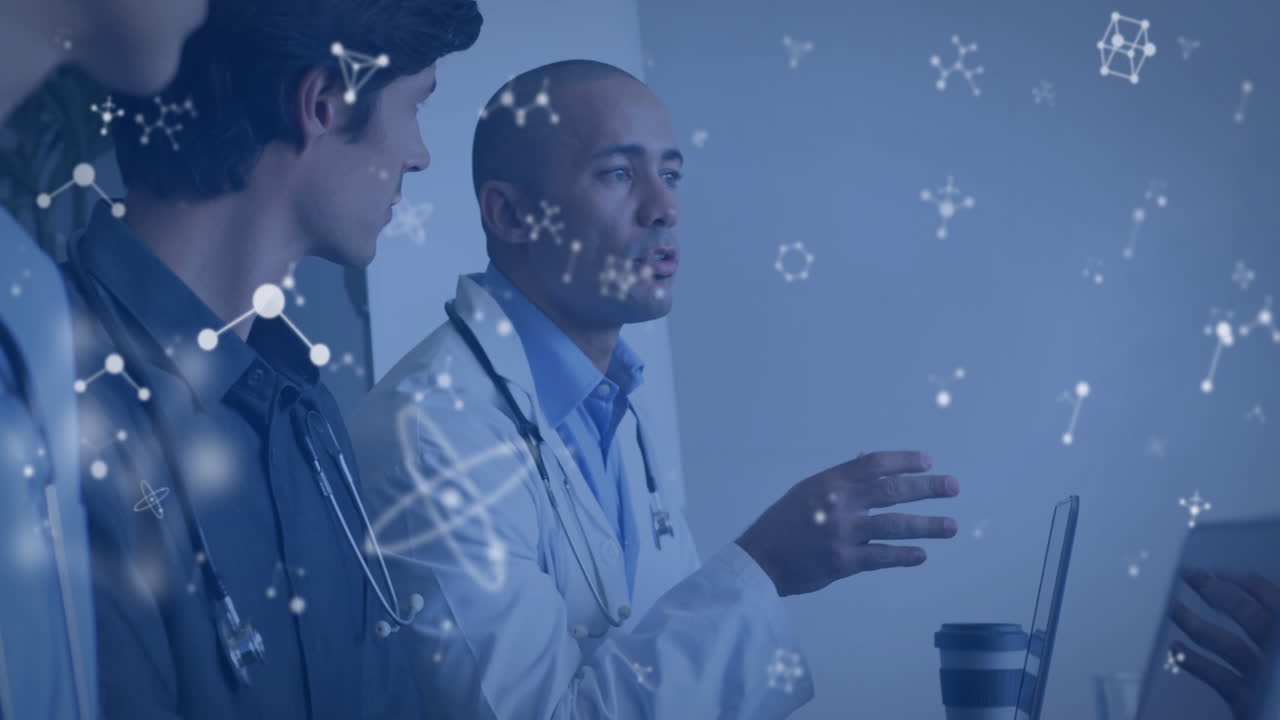 Medical team collaborating around meeting table, reviewing laptop data, showing molecular overlays