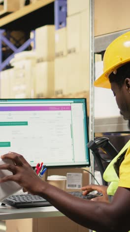 vertical video black depot clerk reviewing inventory data on tracking software