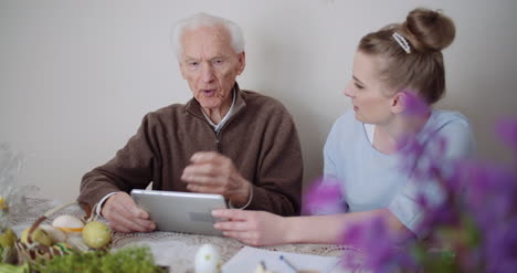 granddaughter with grandfather using digital tablet 4