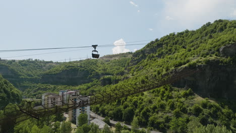 rusty material ropeway with cargo container above chiatura town valley