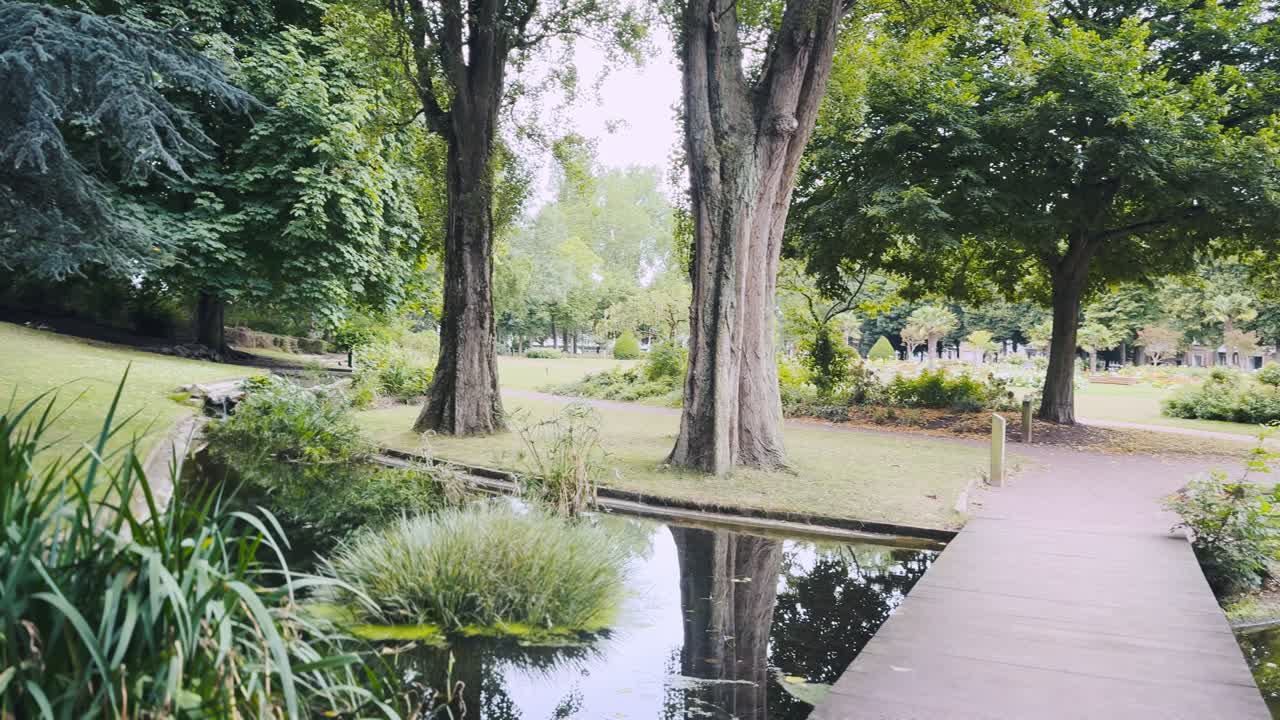 A city park in Calais, France. A wooden bridge over a pond