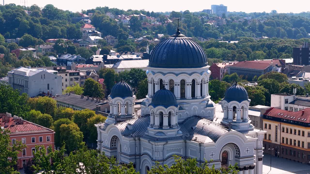 Aerial view of the majestic St. Michael the Archangel Church in Kaunas, Lithuania, surrounded by urban buildings and greenery on a sunny day