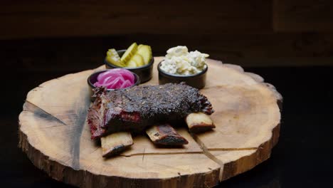 costillas a la barbacoa de un fumador en el plato de madera con toma de camión de encurtidos laterales