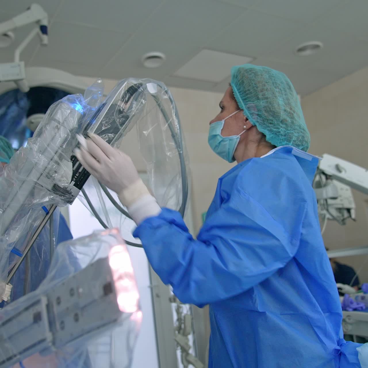 Female medic inserts the part of Da Vinci instrument into the special handle. Robotic system getting ready for the operation