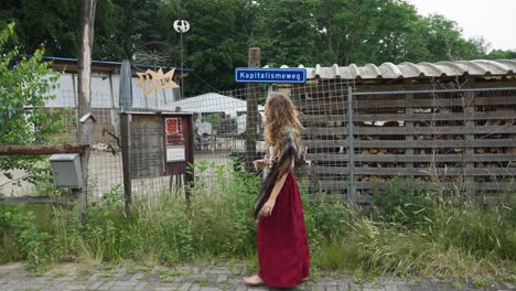 female eco conscious hippie showing sign post to sustainable village living