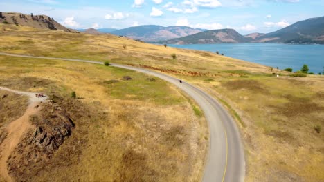 Montando-Una-Motocicleta-Harley-Davidson-Chopper,-En-Un-Viaje-Por-Carretera,-A-Lo-Largo-De-Una-Ruta-Panorámica-Con-Vista-Al-Lago.