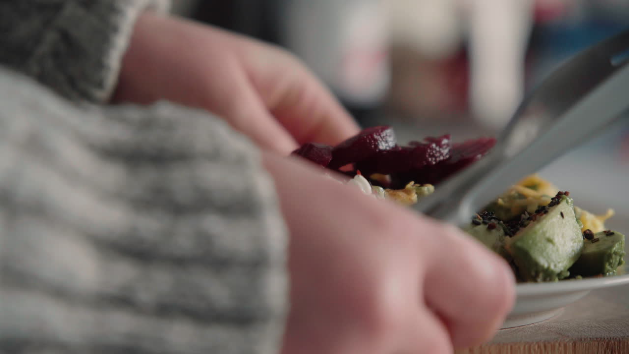 mujer tomando su saludable almuerzo rico en proteínas de una tabla de cortar de madera