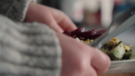 mujer tomando su saludable almuerzo rico en proteínas de una tabla de cortar de madera