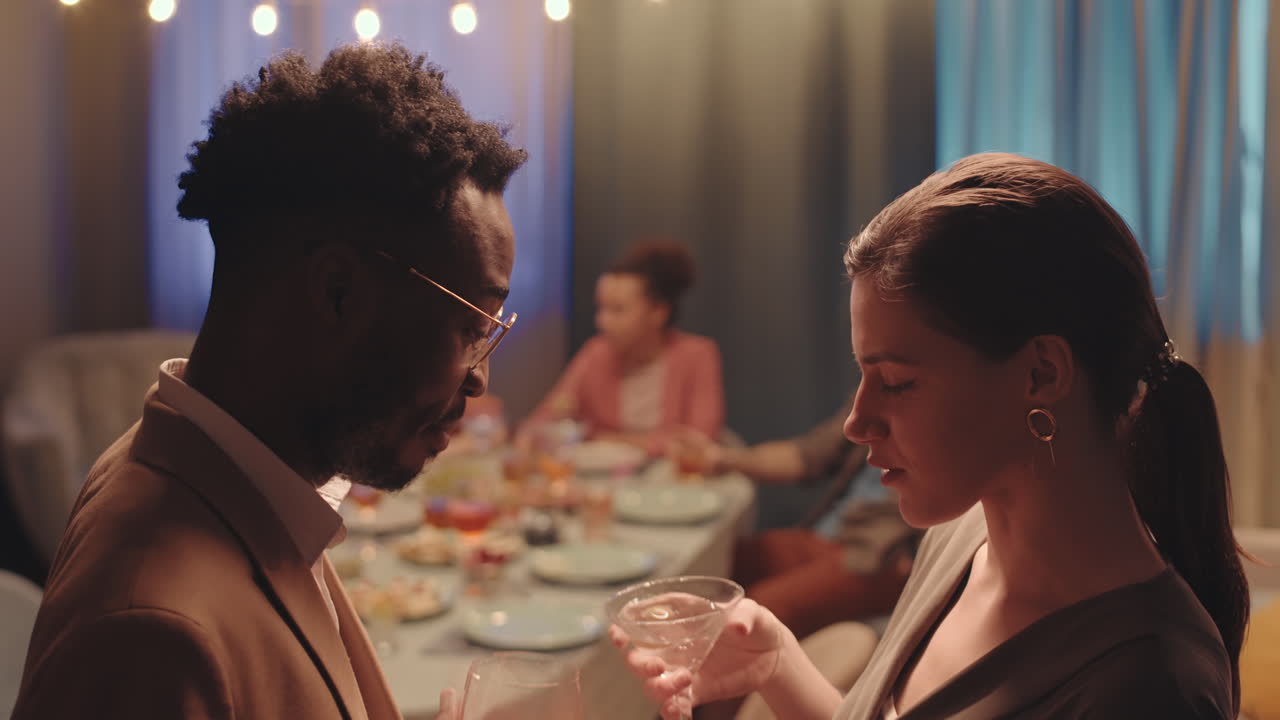 Multiethnic Couple Drinking Cocktails at Dinner Party