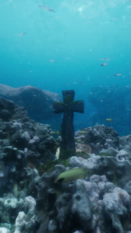 a cross submerged underwater in a coral reef