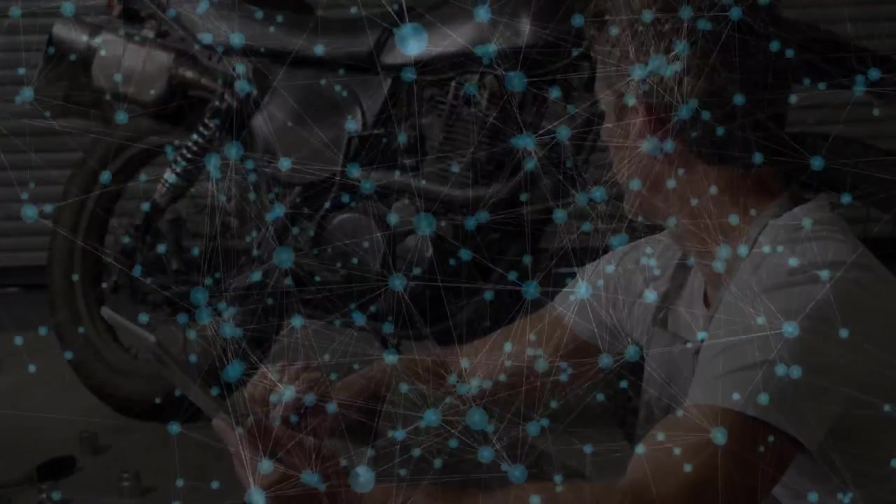 Uomo che ispeziona il motore di una moto in officina e tocca un tablet mentre diagnostica tramite nodi luminosi.