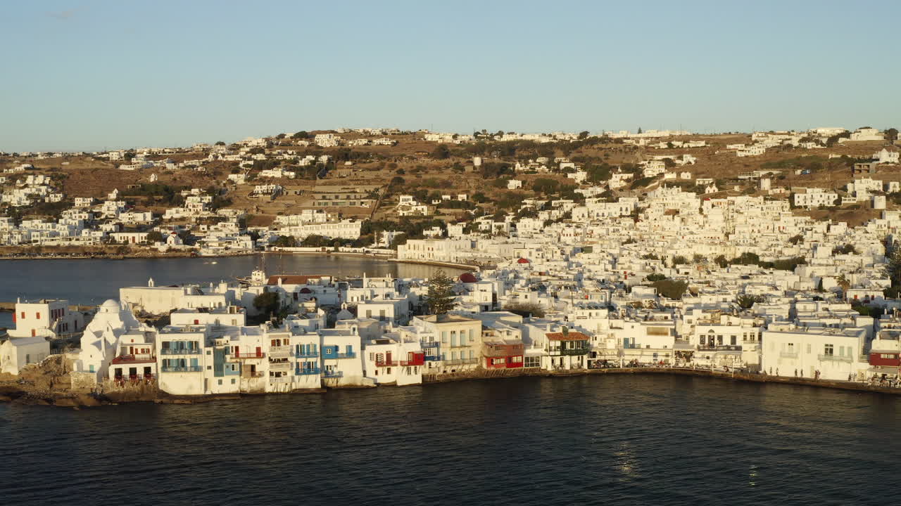 toma aérea de drones cinemáticos suaves de la ciudad de mykonos en el paseo marítimo en 4k